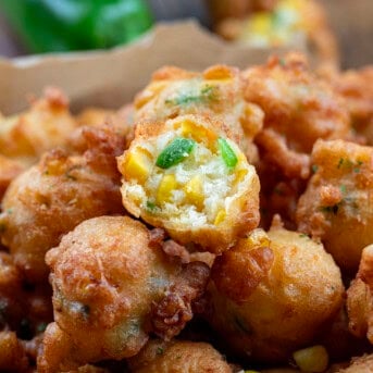 Pan of Jalapeno Corn Nuggets with one nugget halved showing tender dough inside.