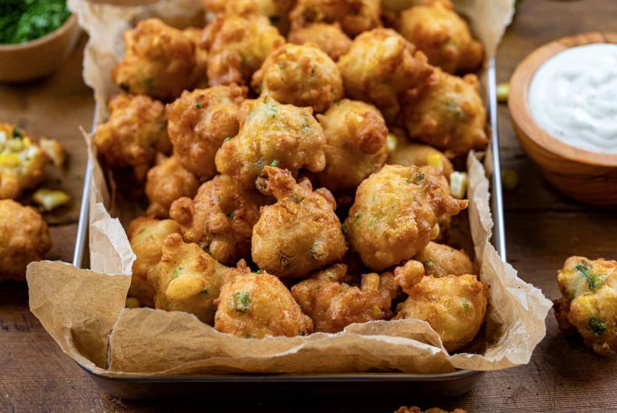 Close up of a pan of Jalapeno Corn Nuggets on a wooden table.