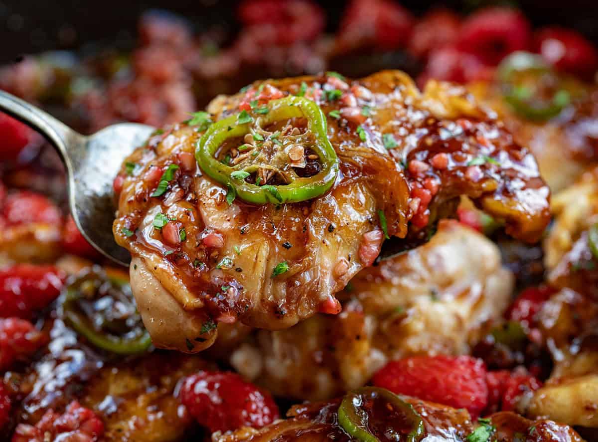 Serving spoon holding a piece of Jalapeno Raspberry Chicken.