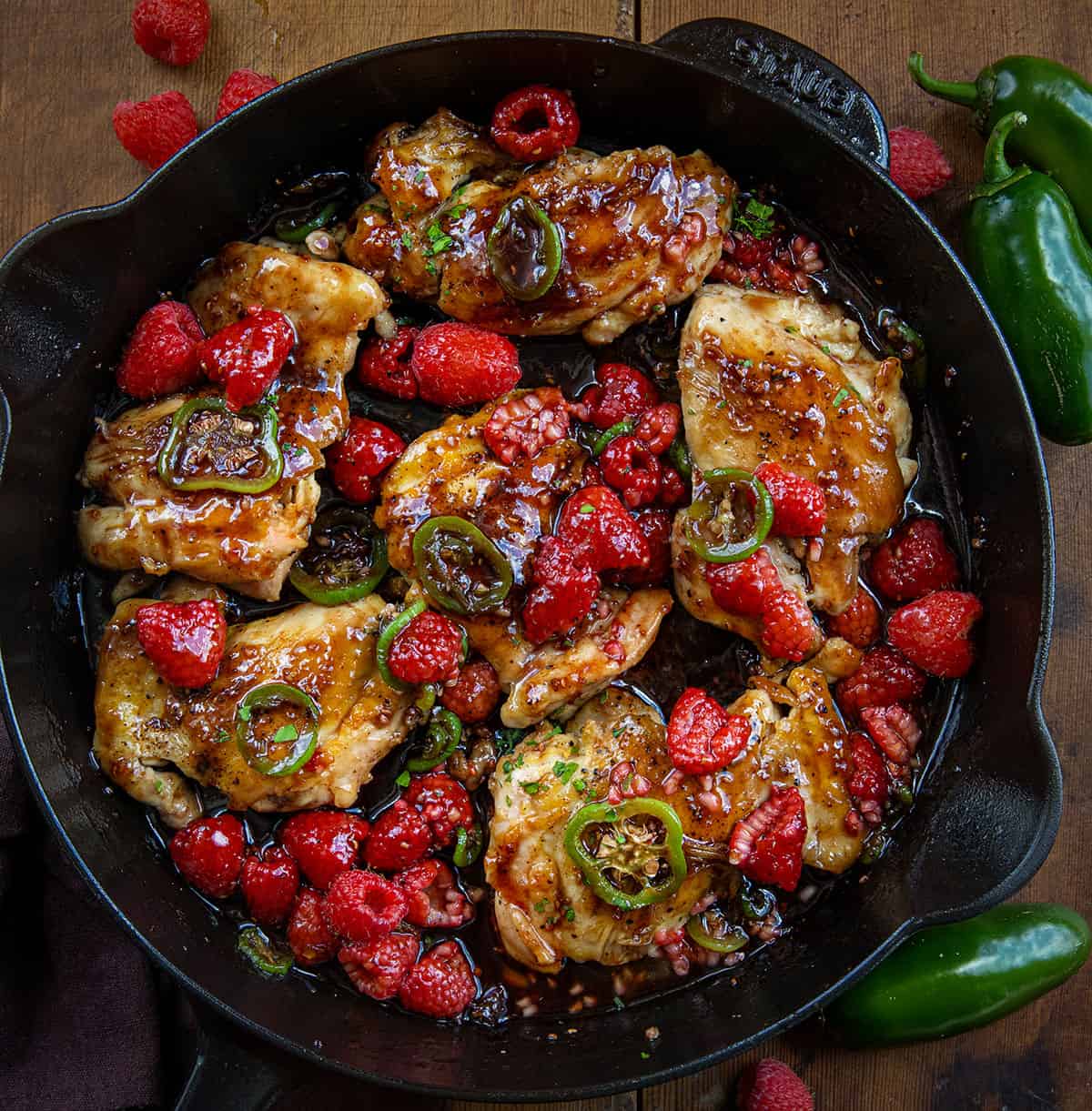 Skillet of Jalapeno Raspberry Chicken on a wooden table from overhead.