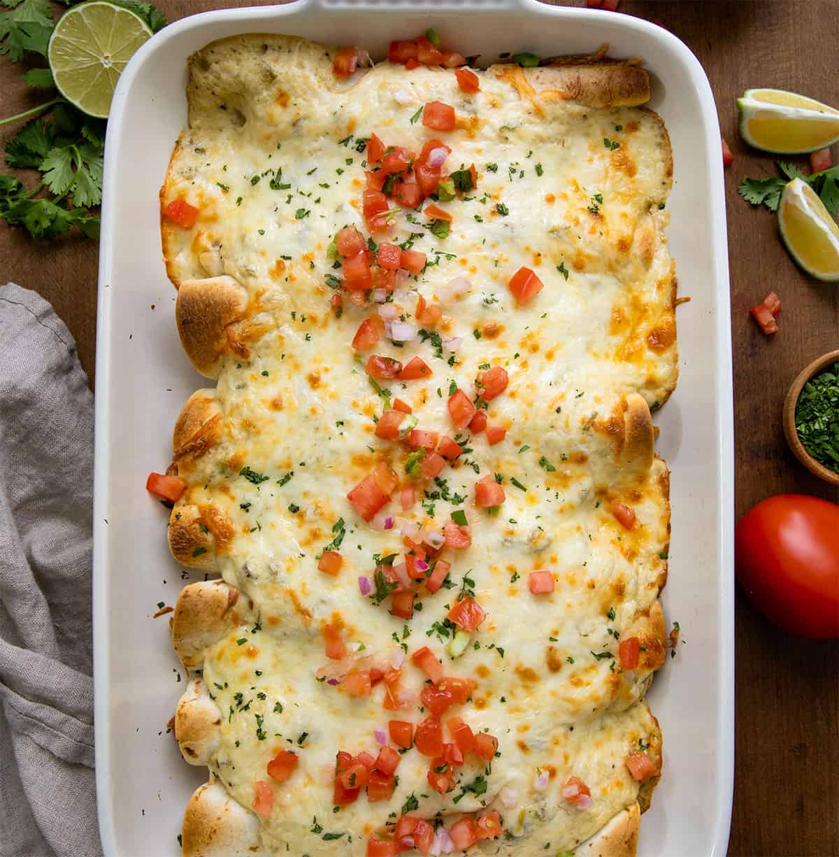 Pan of White Chicken Enchiladas on a wooden table from overhead.