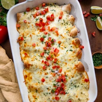 Pan of White Chicken Enchiladas on a wooden table from overhead.