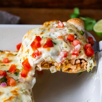 Scooping up a White Chicken Enchilada from casserole pan.