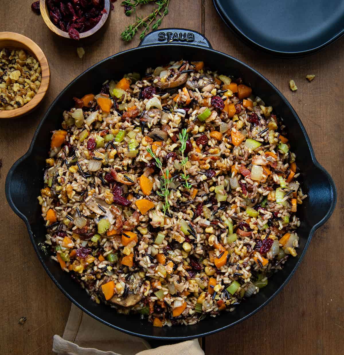 Skillet of Wild Rice Stuffing on a wooden table from overhead. 