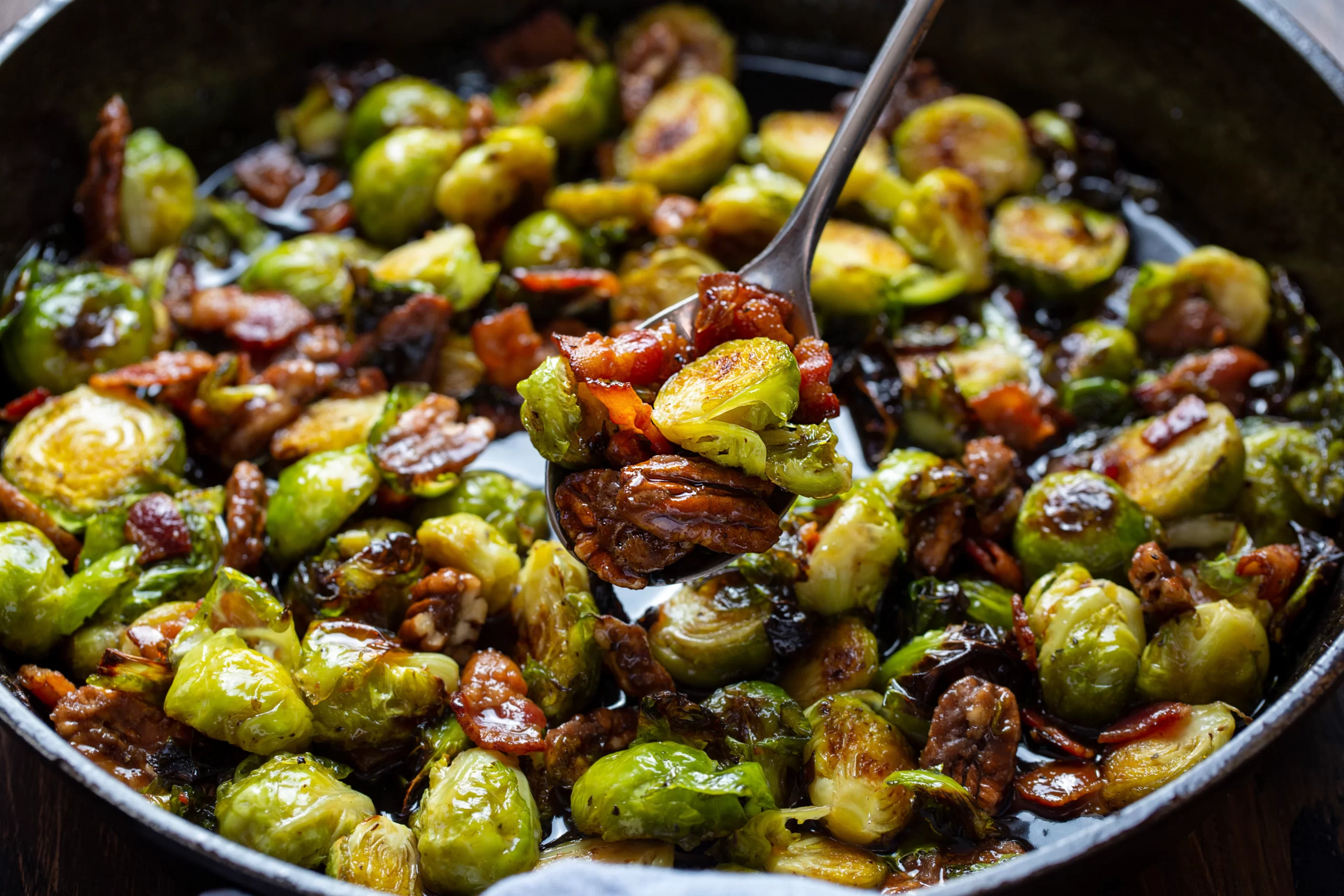 spoon scooping out maple bourbon Brussels sprouts