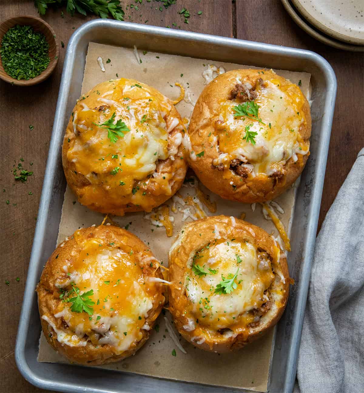 Tray of Sloppy Joe Bread Bowls on a wooden table from overhead.