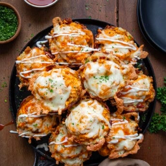 Skillet full of Buffalo Chicken Smashed Potato Cups on a wooden table from overhead.