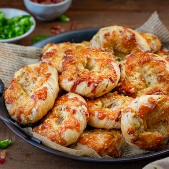 Try of hot Cheesy Bacon Jalapeno Twists With Garlic Butter on a wooden table.