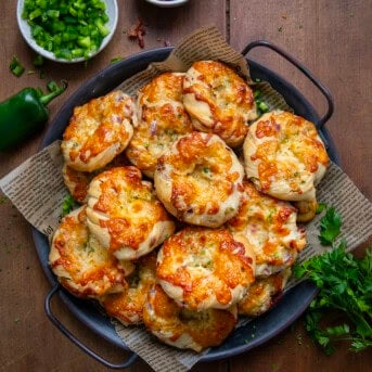 Tray of Cheesy Bacon Jalapeno Twists With Garlic Butter on a wooden table from overhead.