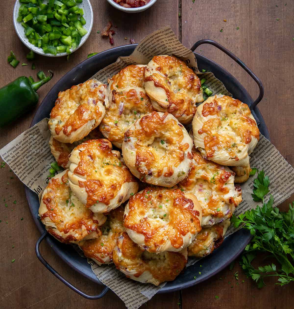 Tray of Cheesy Bacon Jalapeno Twists With Garlic Butter on a wooden table from overhead. 