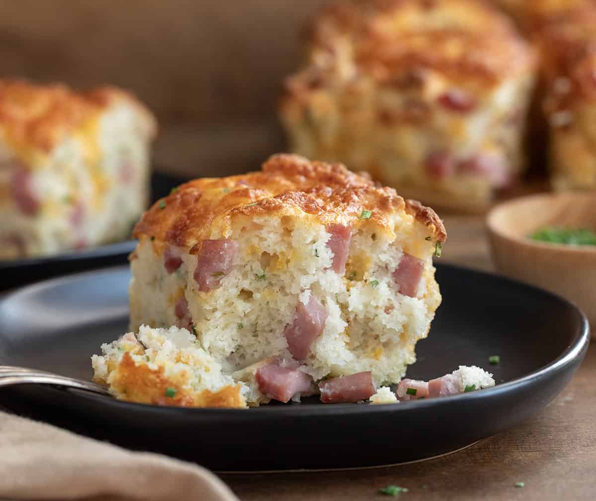 Piece of Ham and Cheese Butter Swim Biscuit on a black plate.