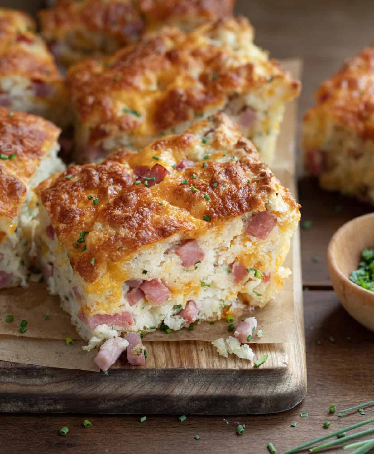 Ham and Cheese Butter Swim Biscuits cut into pieces on a cutting board.