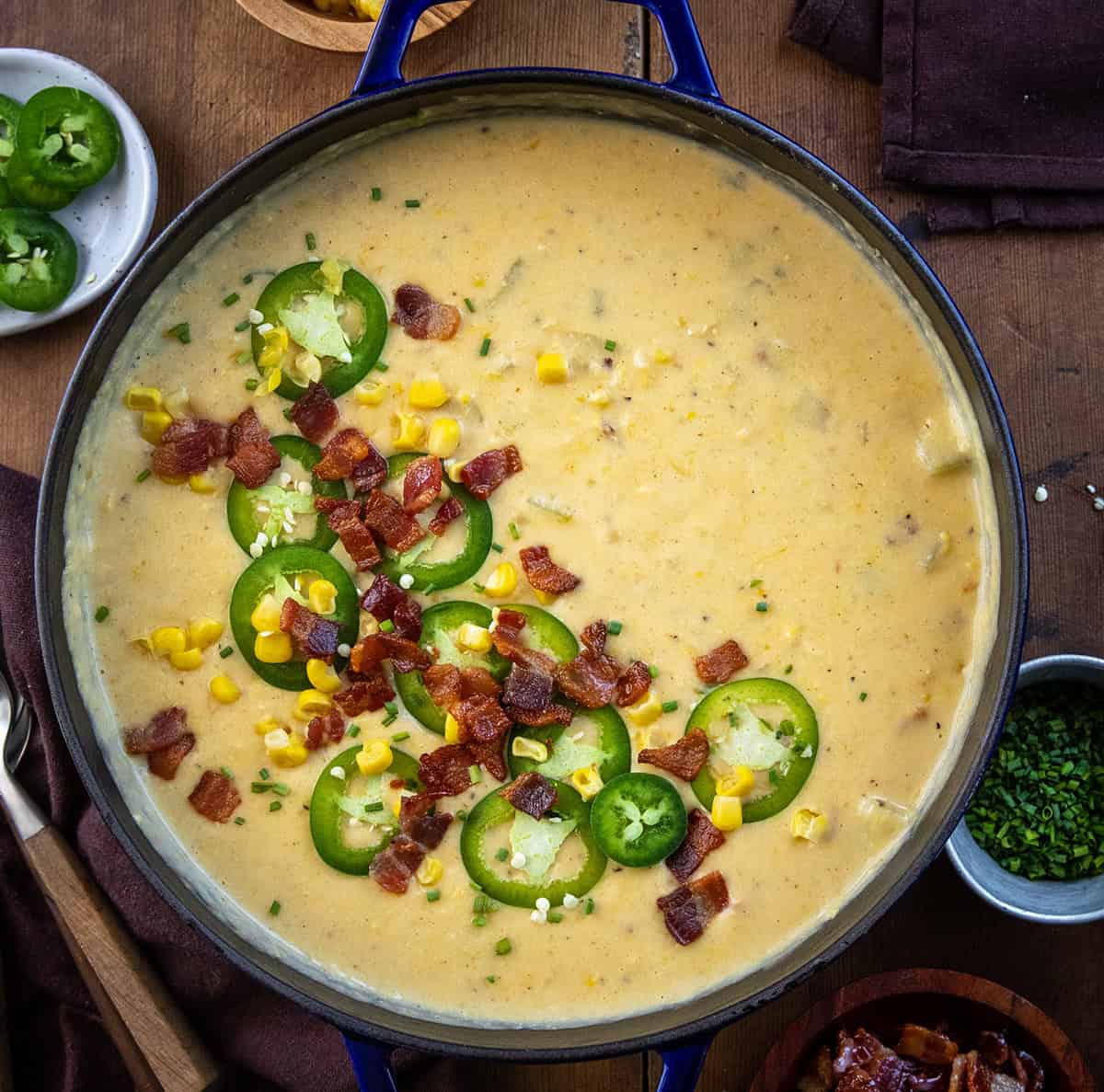 Pot filled with Jalapeno Popper Corn Chowder on a wooden table from overhead.