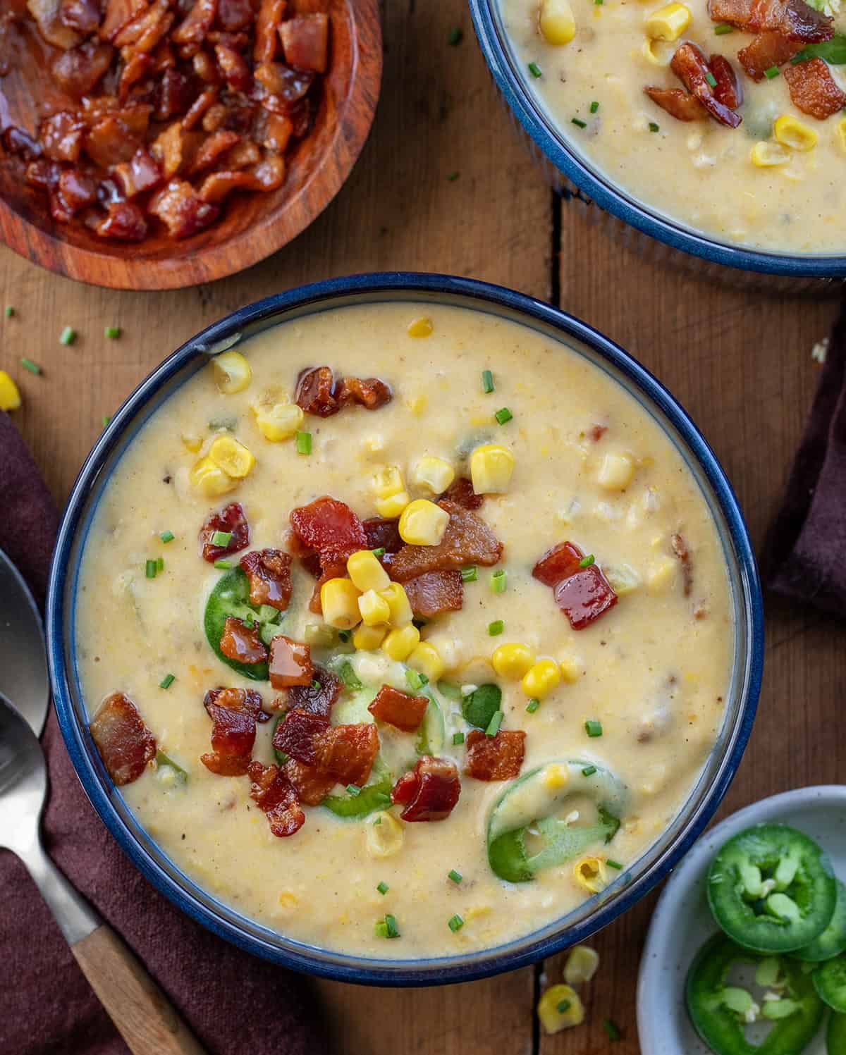 Bowls of Jalapeno Popper Corn Chowder on a wooden table from overhead.