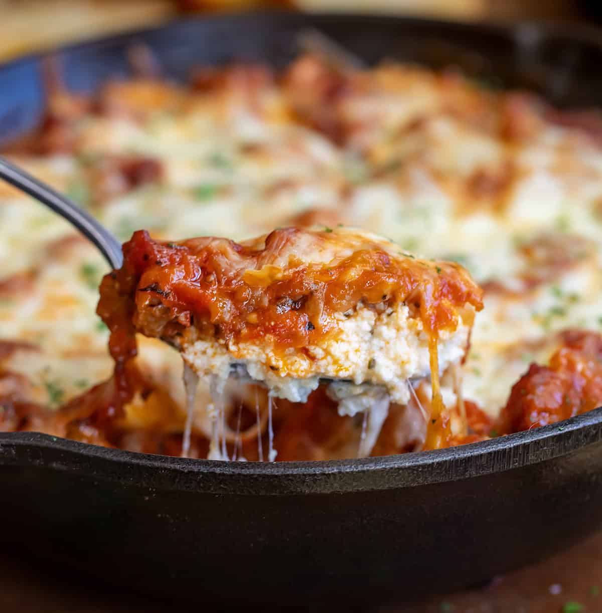 Spoonful of Lasagna Dip coming up from skillet.