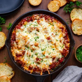 Skillet of Lasagna Dip on a wooden table from overhead.