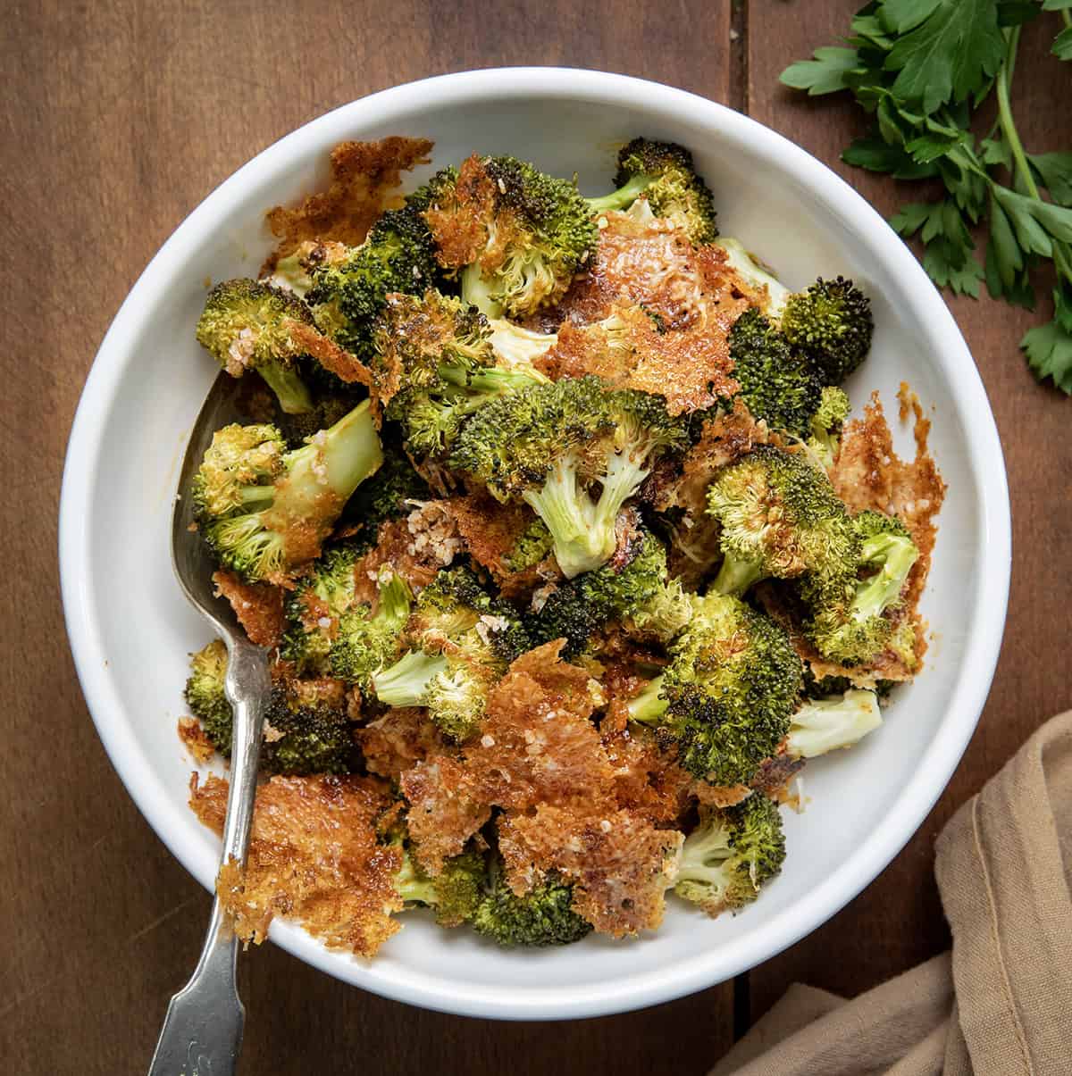 Bowl of Parmesan Crusted Broccoli with a spoon in it from overhead.