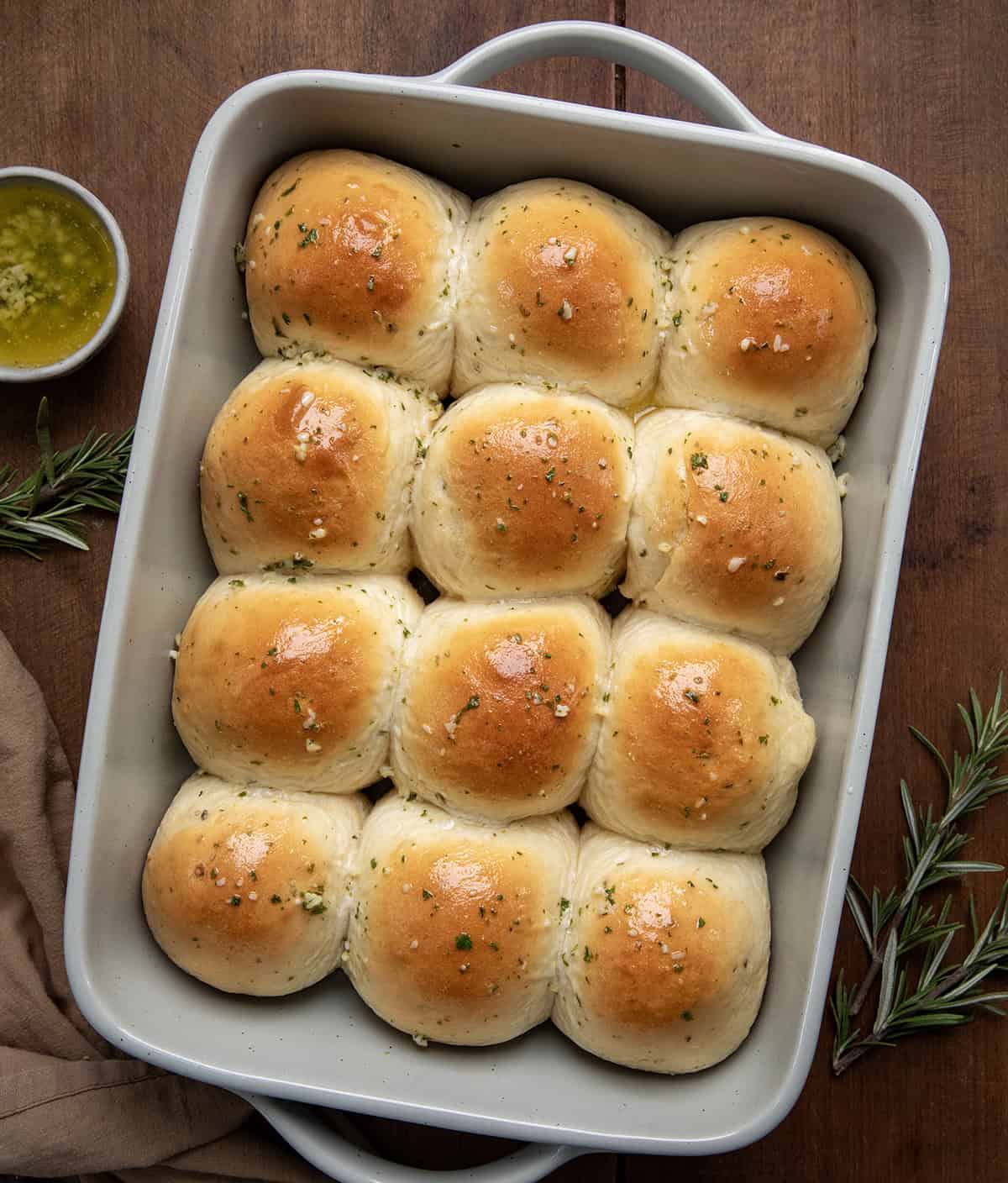 Pan of Rosemary Dinner Rolls on a wooden table from overhead. 