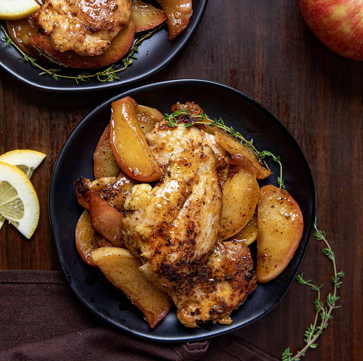 Plates of Apple Chicken on a wooden table from overhead.