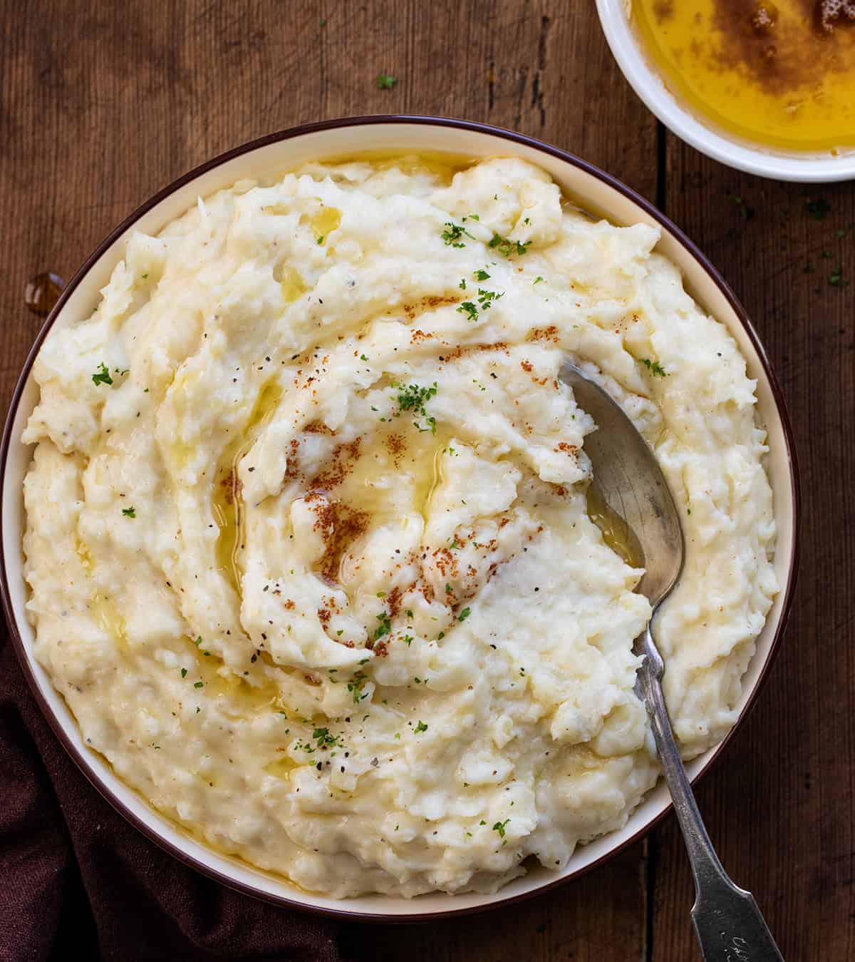 Bowl of Brown Butter Mashed Potatoes on a wooden table from overhead.