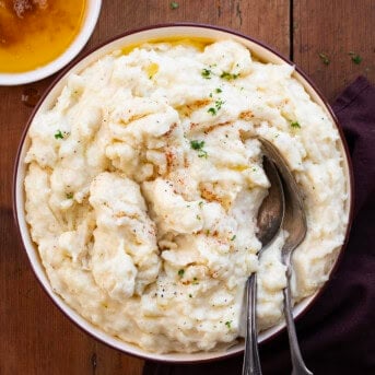 Bowl of Brown Butter Mashed Potatoes on a wooden table from overhead.