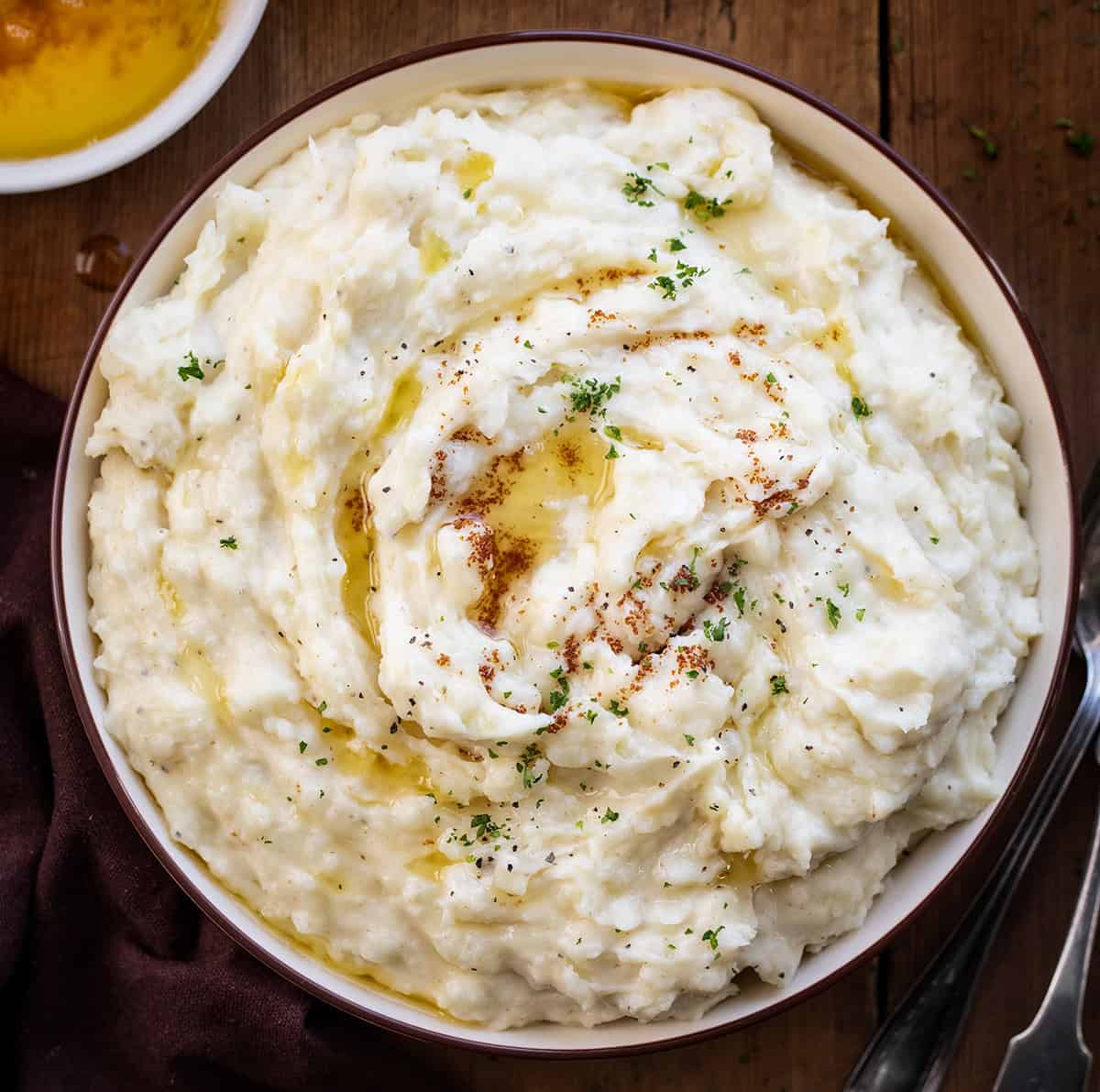 Bowl of Brown Butter Mashed Potatoes on a wooden table from overhead.