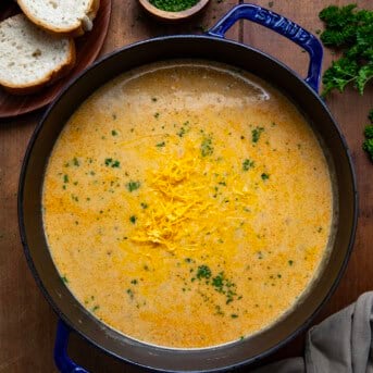 Pot full of Cheesy Beef and Potato Soup on a wooden table from overhead.