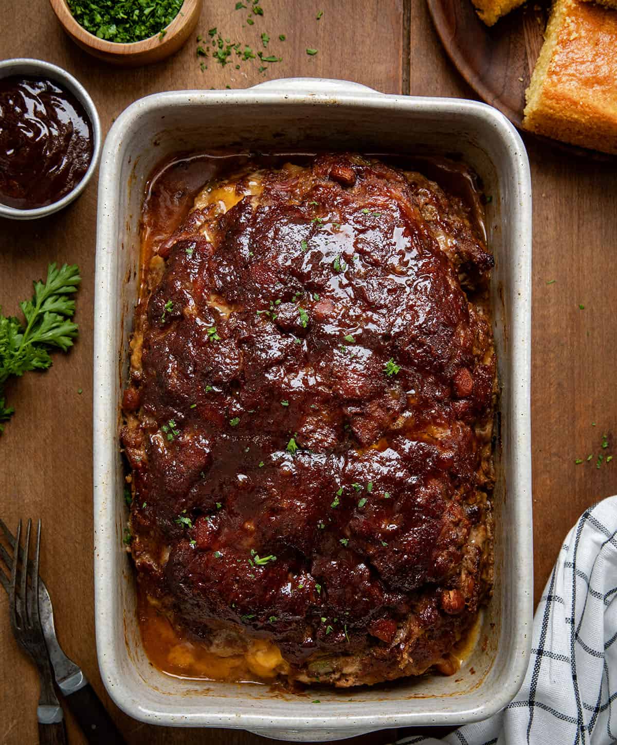 Whole Cowboy Meatloaf in a pan on a wooden table from overhead.