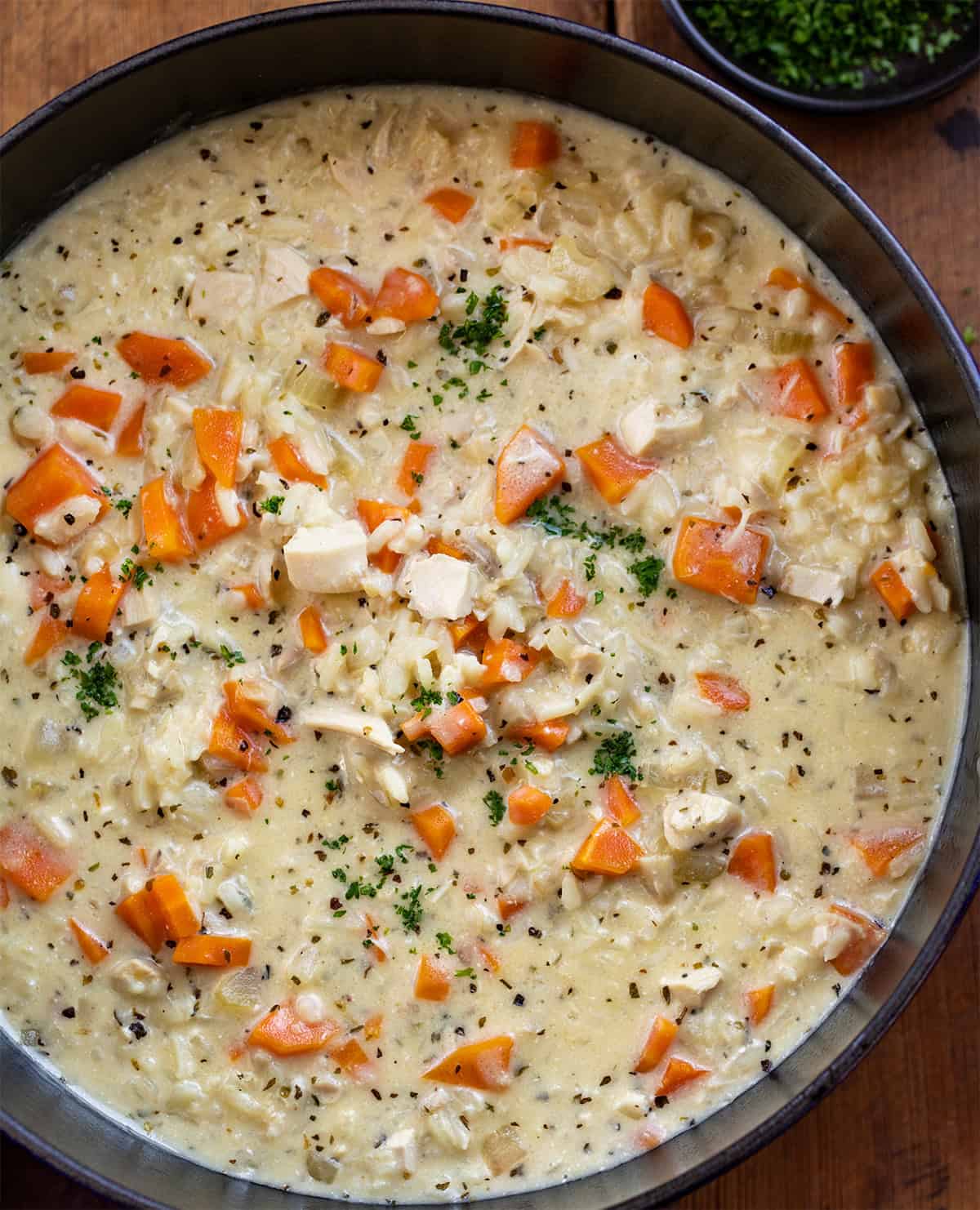 Close up of Crack Chicken Rice Soup in the pot on a wooden table. 