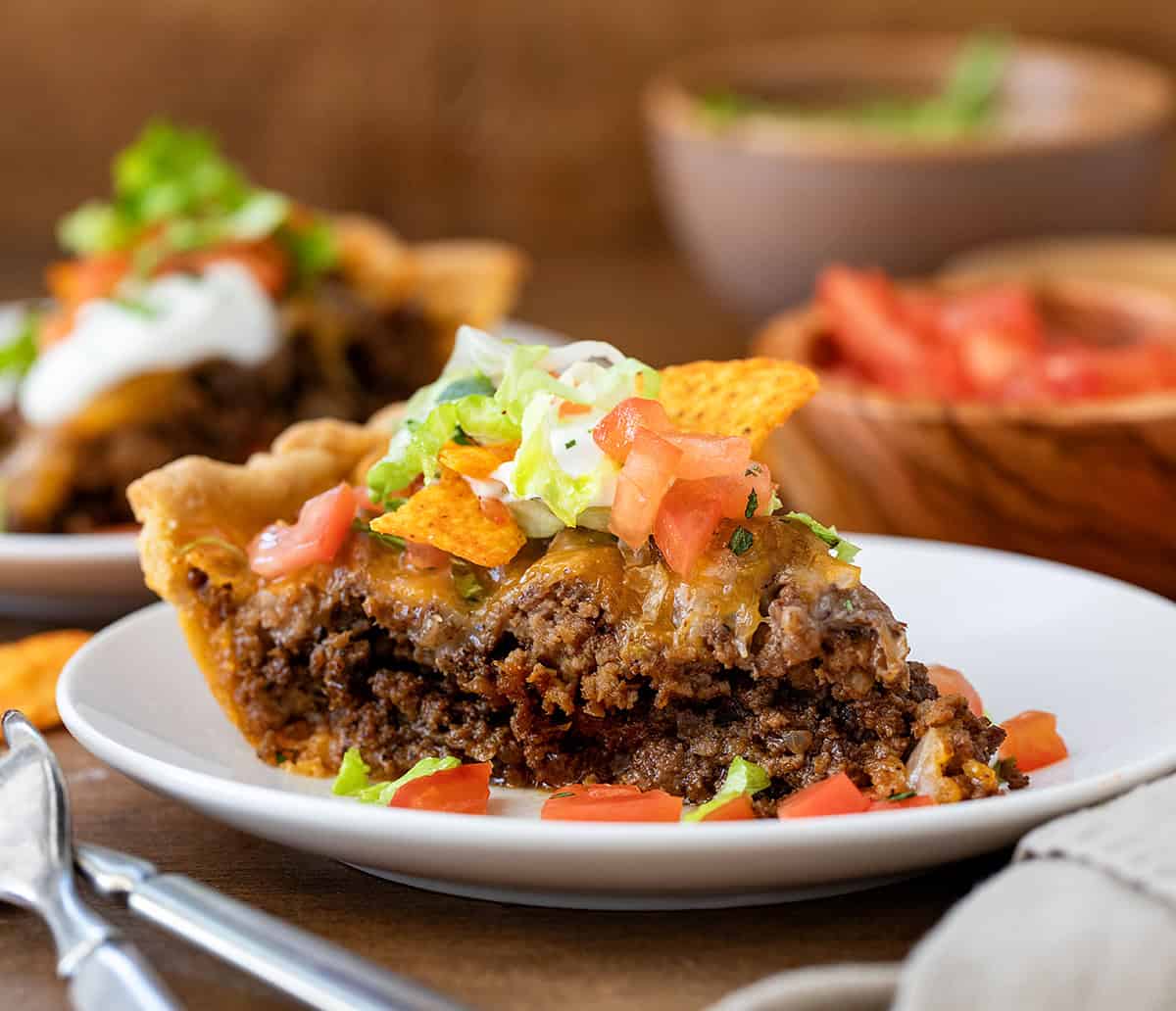 Close up of a piece of Dorito Taco Pie on a white plate.