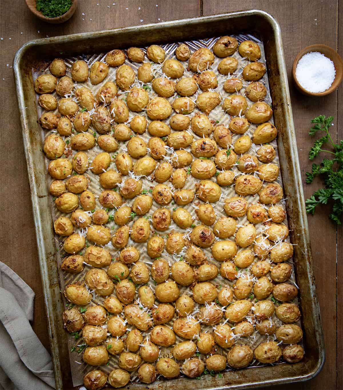 Pan of Garlic Parmesan Roasted Potatoes on a wooden table from overhead.