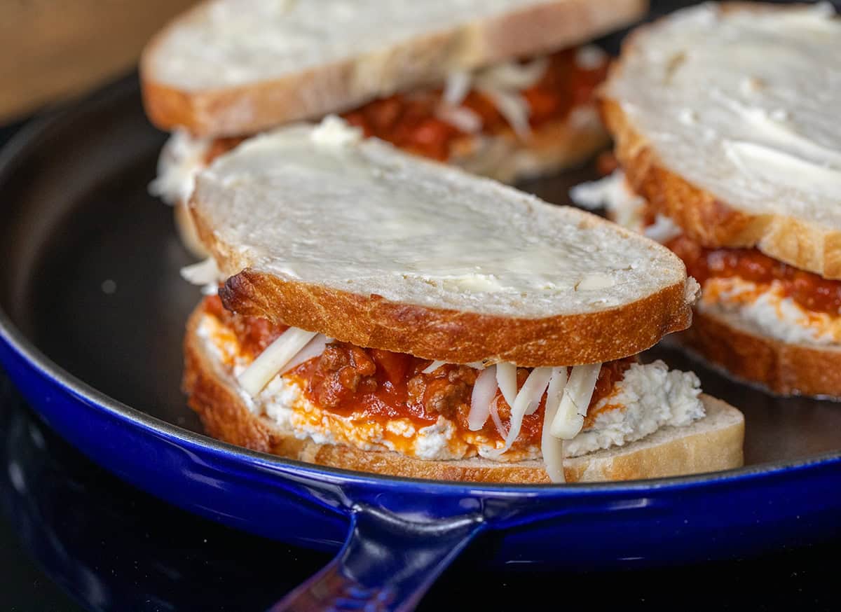 Lasagna Grilled Cheese sandwiches in the pan before browning and melting.