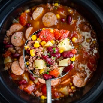 Filled ladle of Slow Cooker Cowboy Soup right above crock pot.