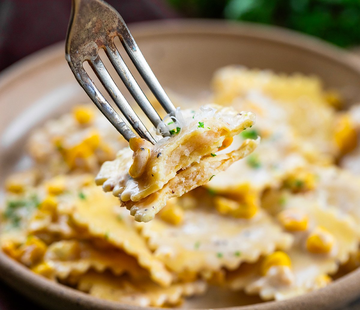 Fork holding Sweet Corn Ravioli on it that was bit into, showing inside texture.