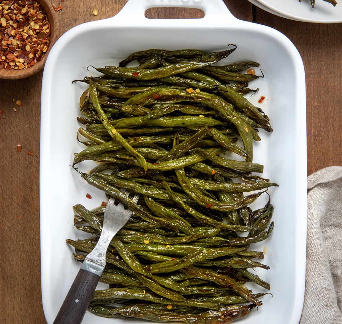 Tray of Sweet and Spicy Green Beans on a wooden table from overhead.