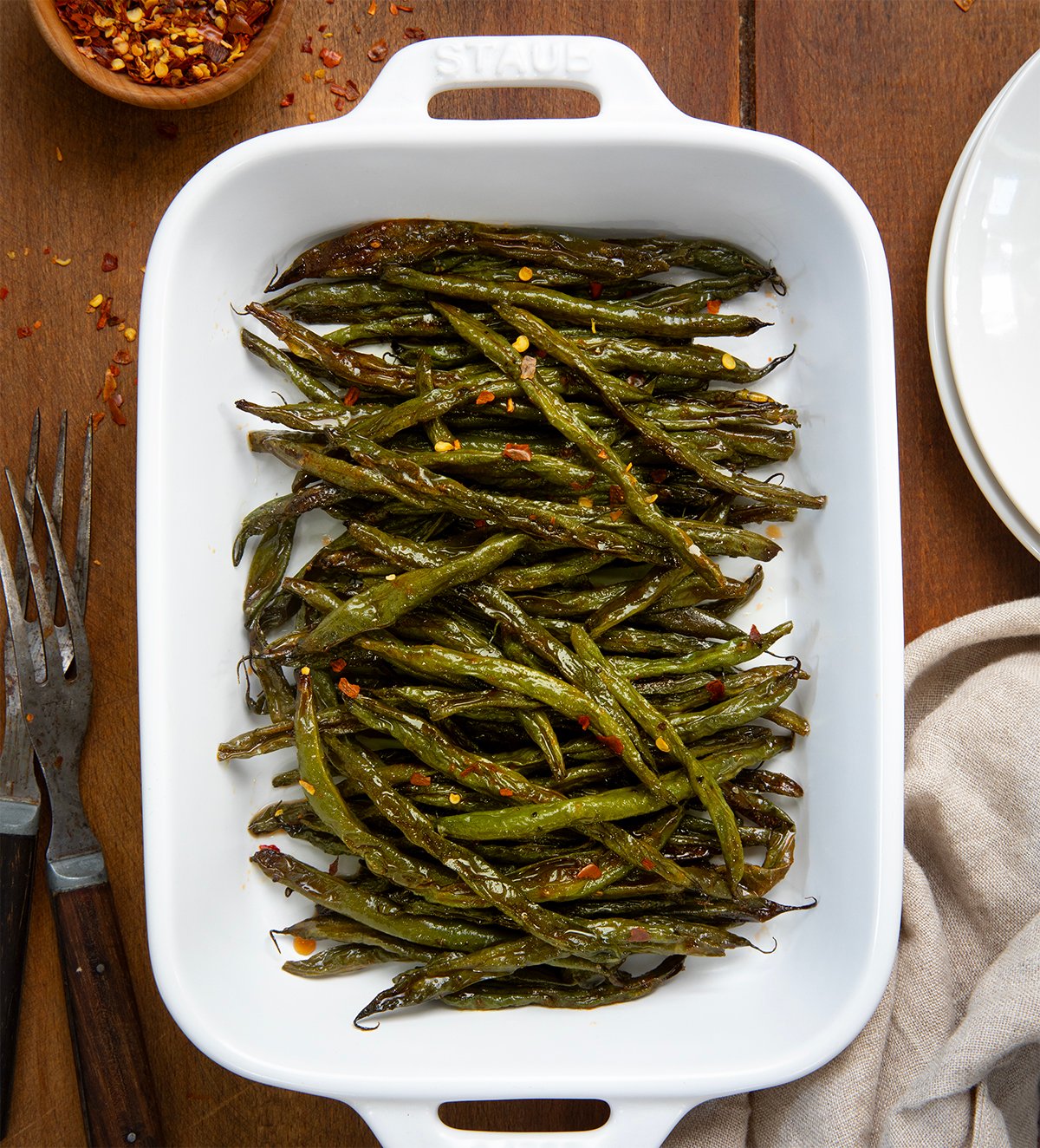 Tray of Sweet and Spicy Green Beans on a wooden table from overhead.