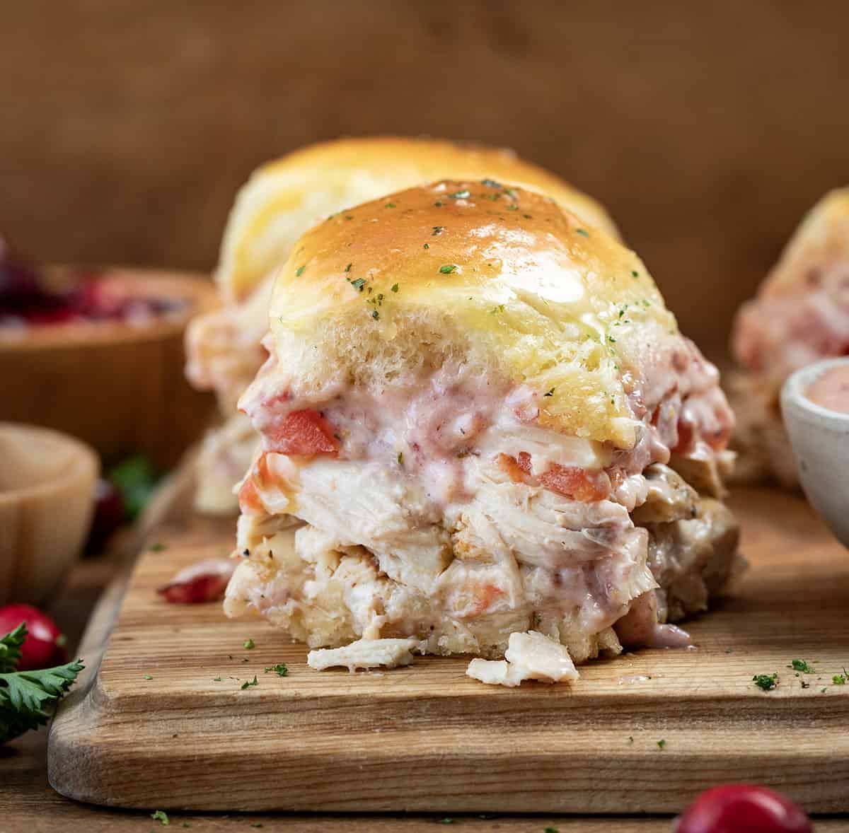 Turkey Melt Sliders with Cranberry Aioli on a cutting board close up.