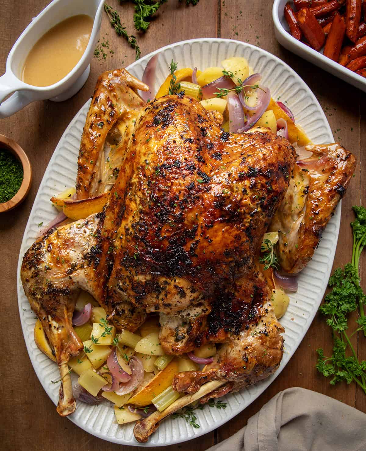 Whole Cowboy Butter Turkey on a platter on a wooden table from overhead.