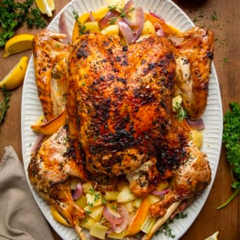 Whole Cowboy Butter Turkey on a platter on a wooden table from overhead.