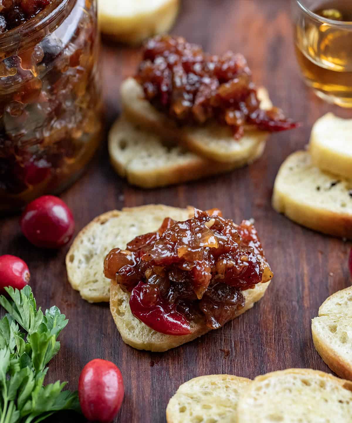 Bagel chips with Cranberry Bacon Jam scooped on them.