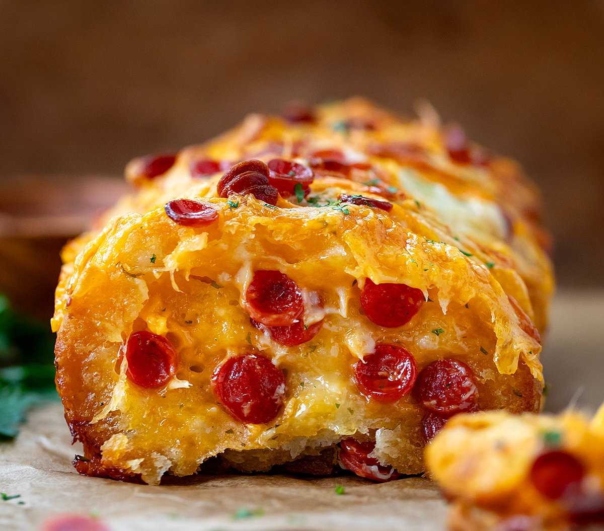 Loaf of Pepperoni Pull Apart Bread with a piece removed showing cheesy pepperoni filled inside.