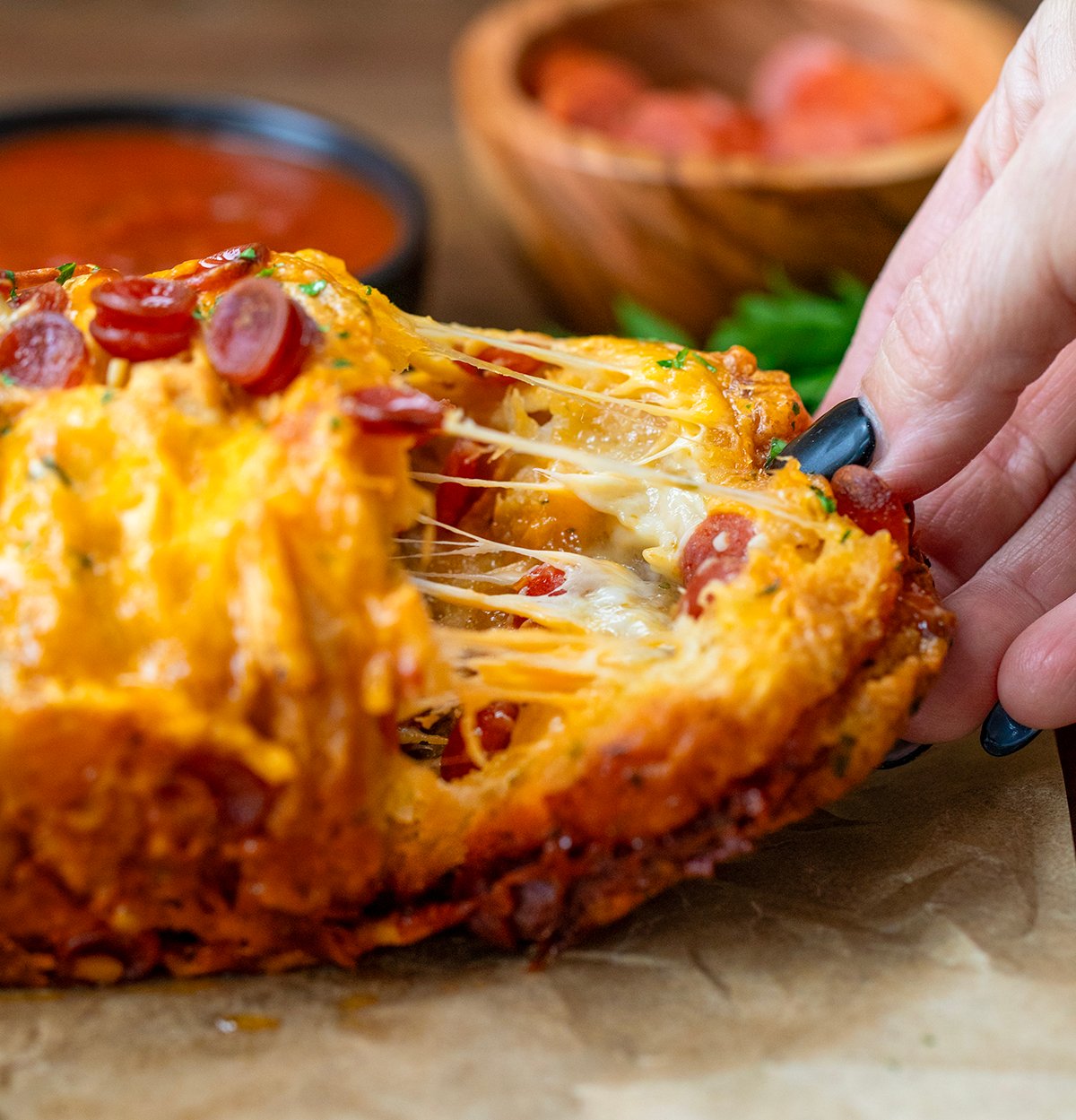 Pulling a piece of Pepperoni Pull Apart Bread off of the loaf.