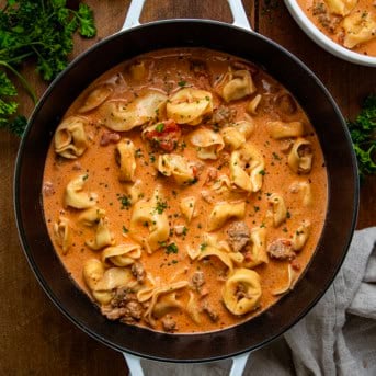 Pot of Sausage Tortellini Soup on a wooden table from overhead.