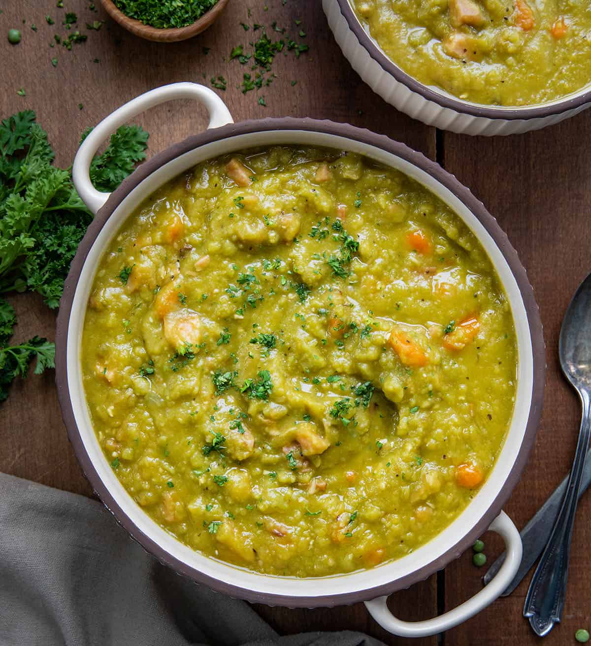 Bowls of Split Pea and Ham Soup on a wooden table from overhead.