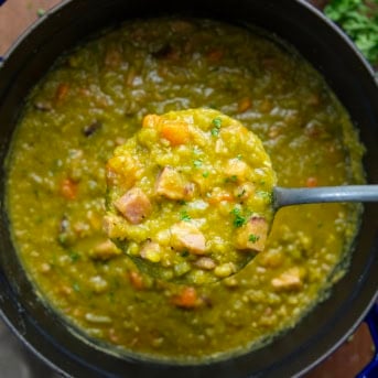 Holding a ladle full of Split Pea and Ham Soup over the pot.