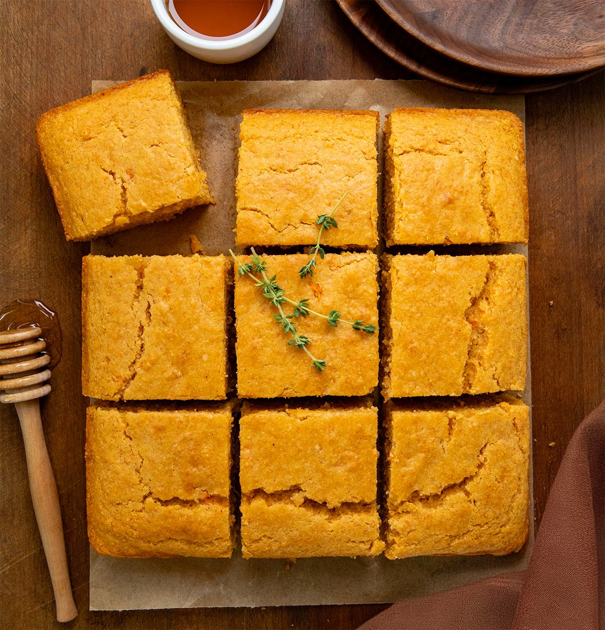 Sweet Potato Cornbread cut into pieces on a wooden table from overhead.