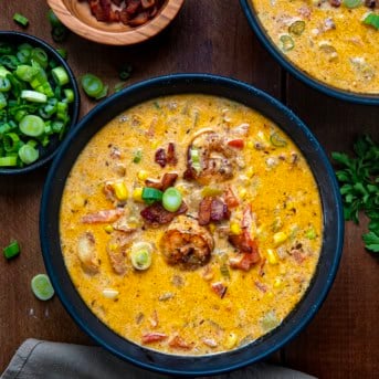 Bowls of Blackened Shrimp and Corn Chowder on a wooden table from overhead.