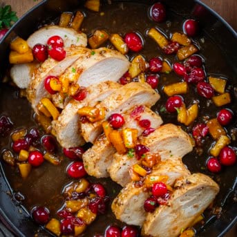 Sliced Cranberry Apple Pork Tenderloin in a black skillet from overhead.