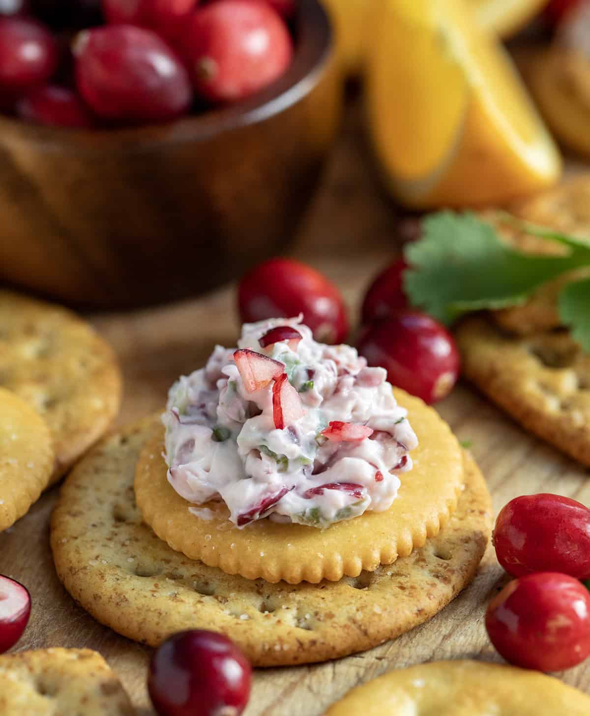 Creamy Cranberry Jalapeño Dip on a cracker set out for a Christmas event.