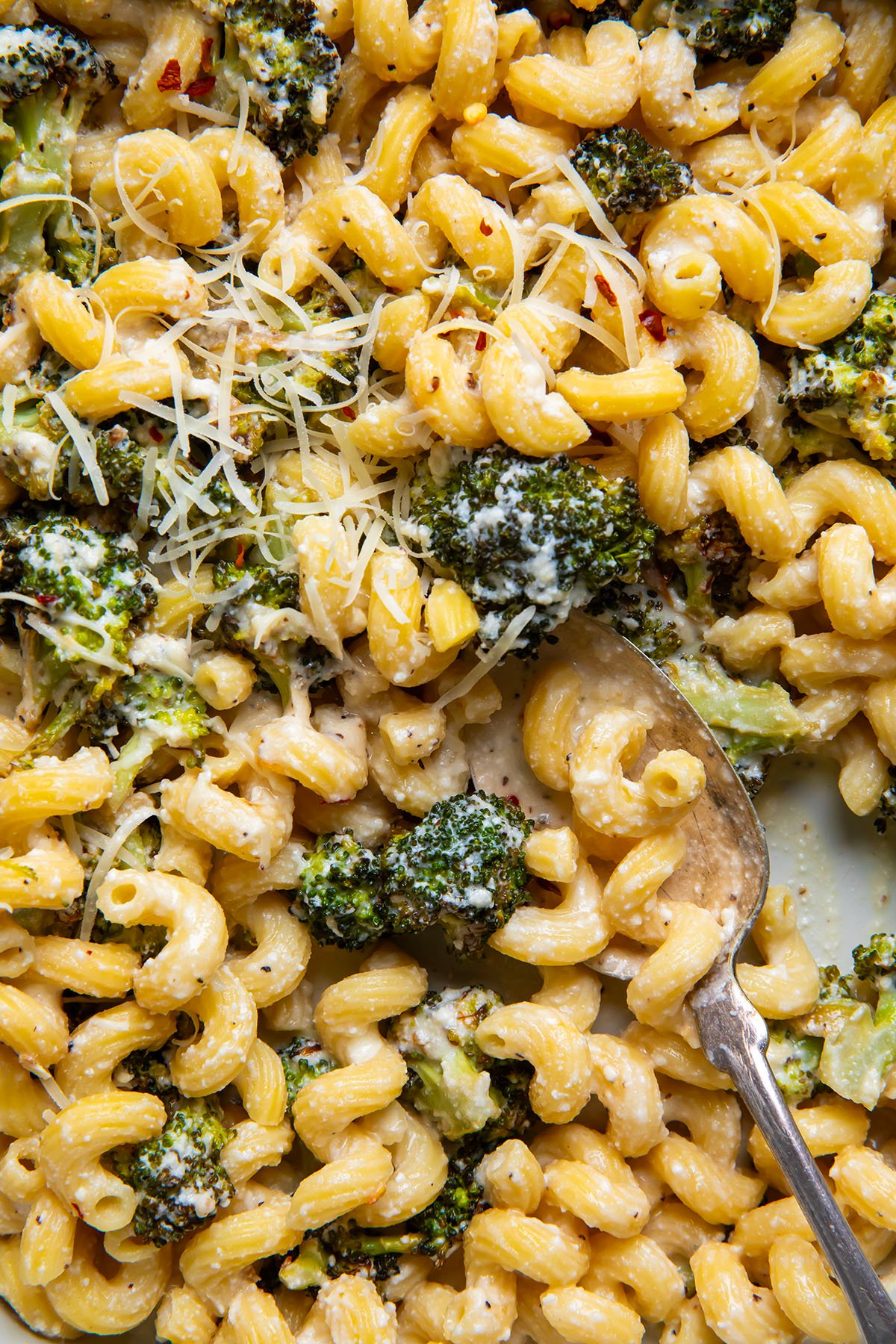 Close up of Creamy Ricotta Pasta with Roasted Broccoli with a spoon in the pan.